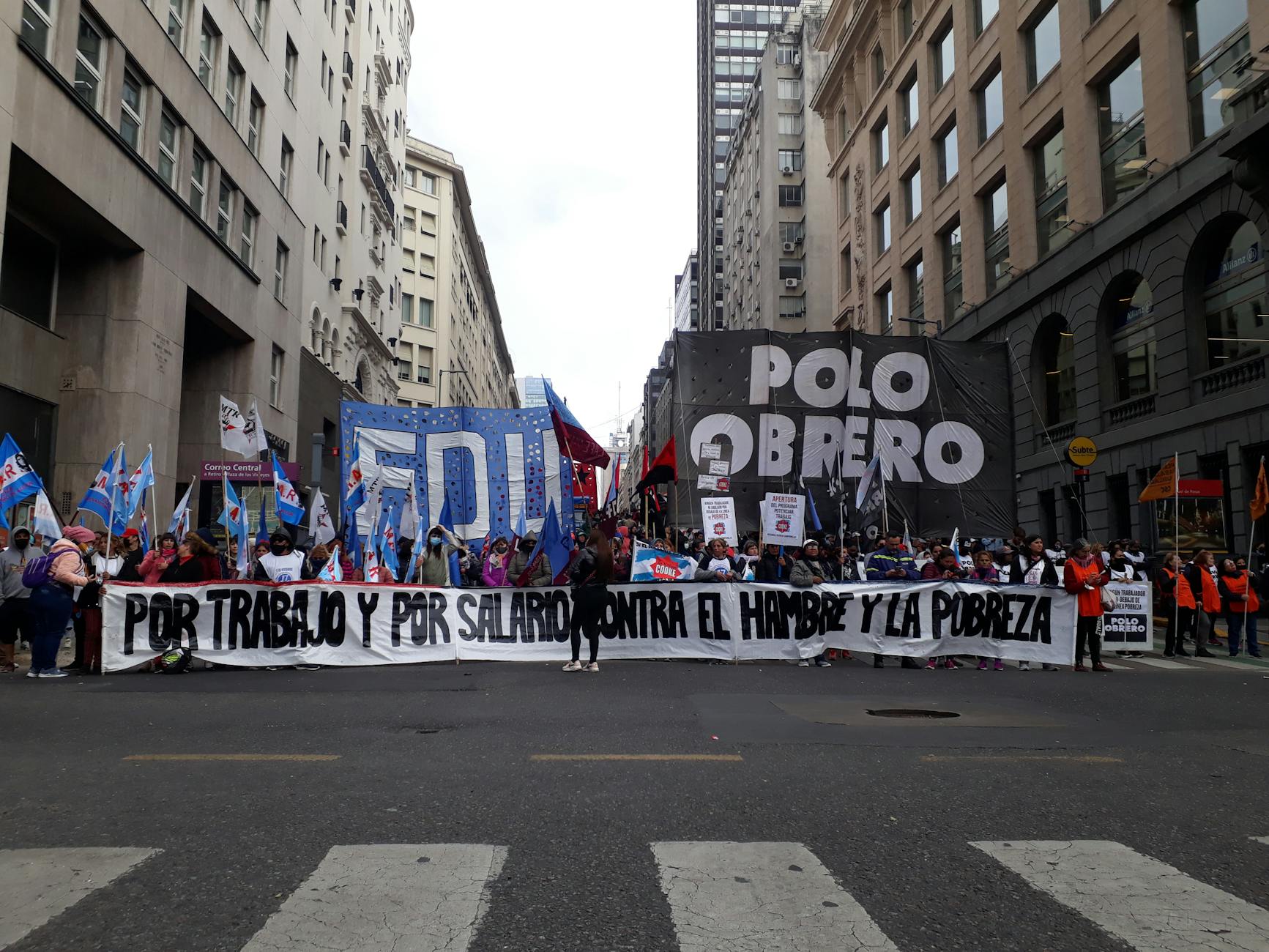 Demonstracja w mieście z transparentami o prawach pracowniczych i biedzie