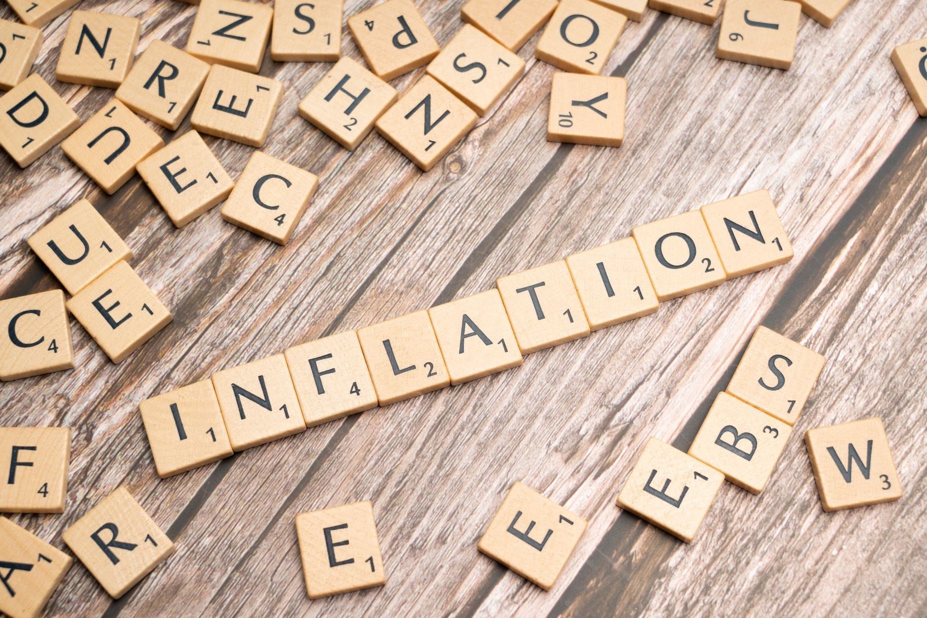 Drewniane kostki z napisem inflation na starym drewnianym blacie