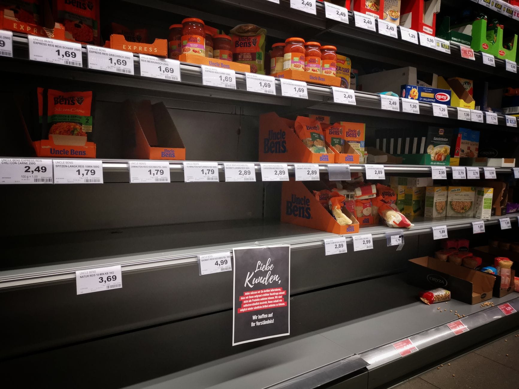 Półpuste półki w supermarkecie z produktami w słoikach i pojemnikach Półpuste półki w supermarkecie z produktami w słoikach i pojemnikach